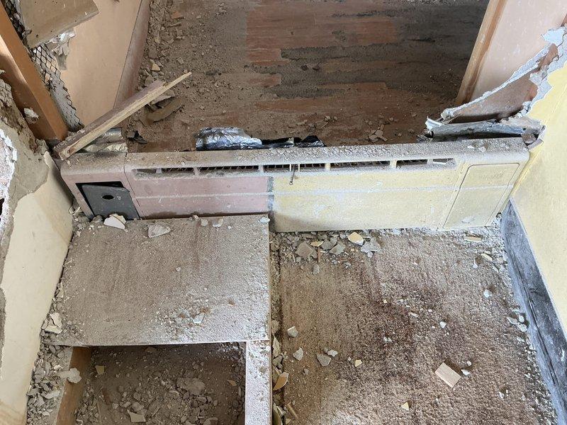 Returned to property to complete estimate assessment for HVAC system work. Documented existing ductwork configuration in garage workshop area, including large gray cylindrical ventilation duct mounted to ceiling and flexible ductwork components. Evaluated electrical connections and control box wiring associated with system. Inspected deteriorated basement utility space showing significant structural damage, including compromised drywall, exposed framing, and damaged concrete flooring. Assessed horizontal ventilation grille component with housing requiring attention. Photographed areas of concern including debris accumulation, material deterioration, and damaged wall sections to support comprehensive estimate preparation for necessary repairs and system modifications.