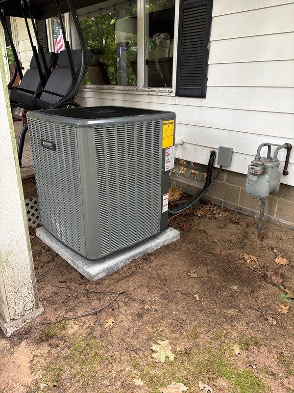 Completed full HVAC system installation including new furnace and air conditioning condenser unit. Installed outdoor AC condenser on composite pad adjacent to home foundation with proper refrigerant line connections and electrical disconnect box mounted to structure. Installed AprilAire whole-home humidifier unit integrated with ductwork system in basement utility area, including humidistat control panel, water supply line with copper tubing, drainage connections, and electrical wiring. All components properly mounted, connected, and positioned for optimal system performance and accessibility for future maintenance.