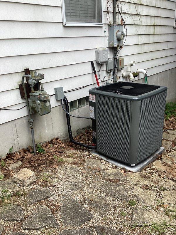 Completed full system replacement including new furnace and air conditioning condenser unit. Installed outdoor condensing unit on concrete pad against exterior wall with proper refrigerant line routing through wall penetration. Interior air handler/furnace installed in basement utility area with new condensate drain pan, PVC drainage piping with proper trap configuration, and insulated refrigerant lines connected to outdoor unit. All electrical connections completed, system tested and operational.