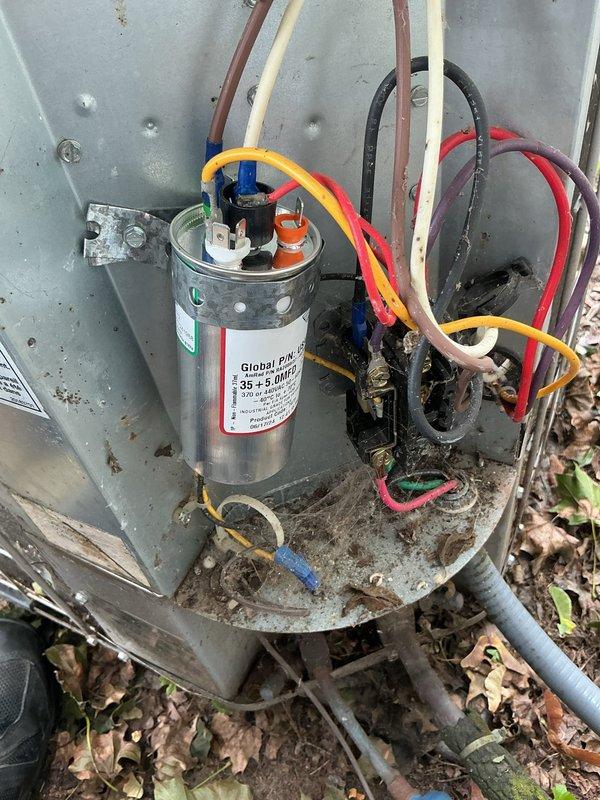 Responded to no cooling complaint on 26-year-old AMA system. Upon arrival, inspected outdoor condenser unit and found capacitor showing signs of age and deterioration with accumulated debris on mounting platform. Intermittent cooling issue reported over past 3-4 weeks consistent with failing capacitor symptoms. Documented equipment condition with photos showing capacitor, electrical connections, and overall unit condition for service records.