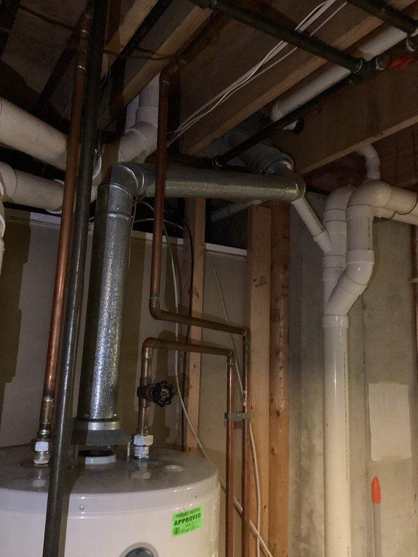 Responded to service call for leaking 14-year-old GE water heater. Upon inspection, documented existing water heater installation and surrounding mechanical systems including connections, piping configuration, and overall unit condition. Provided assessment and recommendations to customer regarding the aging unit.