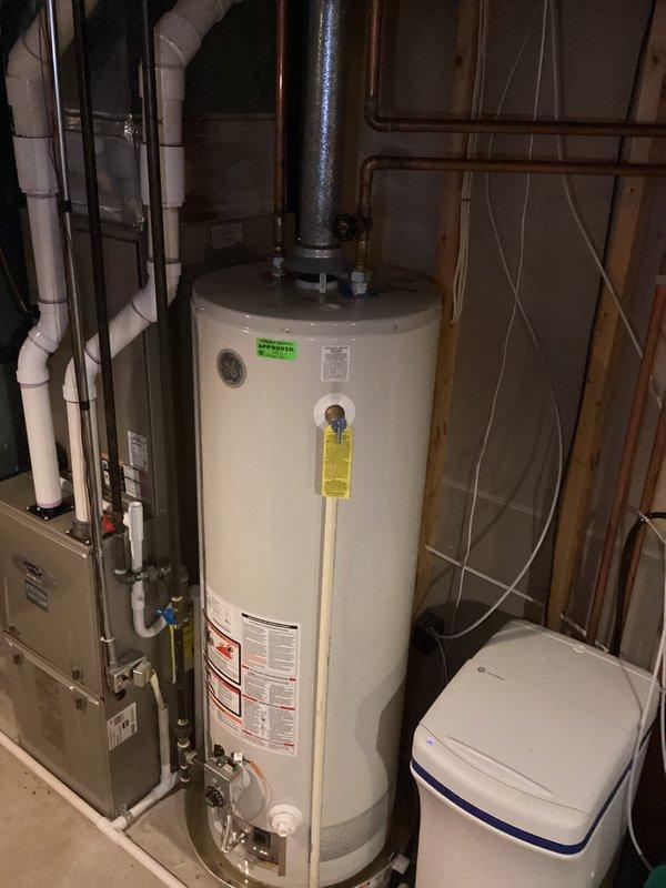 Responded to service call for leaking 14-year-old GE water heater. Upon inspection, documented existing water heater installation and surrounding mechanical systems including connections, piping configuration, and overall unit condition. Provided assessment and recommendations to customer regarding the aging unit.