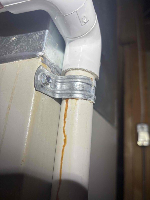 Completed annual cooling maintenance inspection on residential AC system. Performed standard tune-up procedures including filter check, refrigerant level verification, electrical connections inspection, and condensate drain system evaluation. During inspection, identified rust staining on PVC condensate drain piping near metal mounting bracket, indicating previous moisture exposure or mineral deposits. Verified drain line is flowing properly with no active leaks present. All system components operating within normal parameters at time of service.