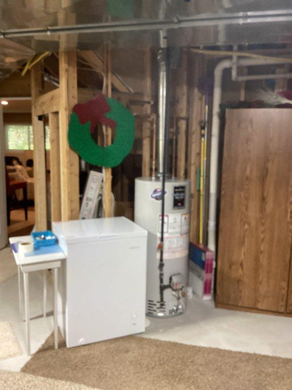 Responded to service call for malfunctioning sump pump with odor complaint. Upon arrival, conducted thorough inspection of basement utility area and mechanical systems. Assessed water heater, plumbing connections, and surrounding infrastructure for potential sources of malfunction and foul odor. Documented existing conditions through photographic evidence showing utility room layout, exposed framing, and mechanical equipment placement. Identified sump pump failure and investigated drainage system for blockages or stagnant water causing odor issues. Performed necessary repairs to restore proper pump operation and addressed sanitation concerns in the sump basin area.
