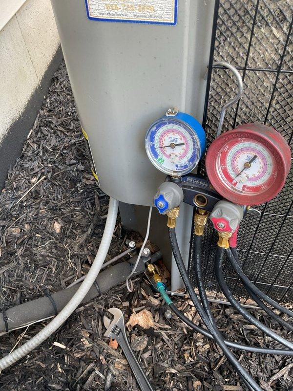 Responded to no-cooling complaint on 20-year-old residential air conditioning unit. Upon arrival, found evaporator coil completely frozen with ice buildup, preventing proper heat exchange and airflow. Connected manifold gauge set to measure system pressures and diagnosed low refrigerant charge as primary cause of freezing condition. System was operating below normal suction pressure, causing evaporator temperature to drop below freezing point. Added refrigerant to bring system pressures within manufacturer specifications. Monitored system operation to ensure proper defrost of coil and return to normal cooling function. Unit restored to operational status with adequate cooling capacity.