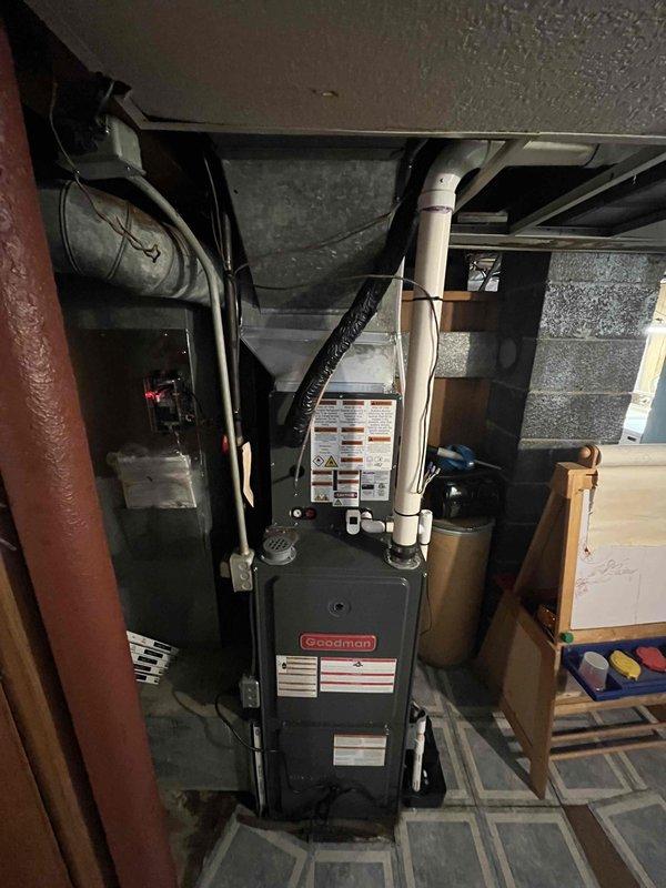 Completed full HVAC system replacement in basement utility area. Removed existing equipment and installed new Goodman furnace unit with associated ductwork modifications. Configured white PVC venting and condensate drainage lines for proper system operation. Connected black flexible ducting and integrated with existing metal ductwork infrastructure. Verified all electrical connections, tested system startup sequence, and confirmed proper airflow throughout the installation. System operational and ready for service.
