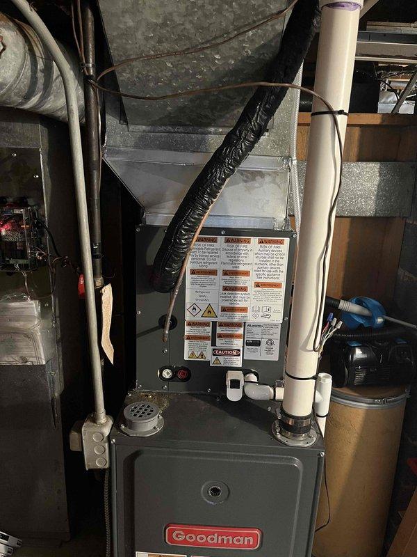 Completed full HVAC system replacement in basement utility area. Removed existing equipment and installed new Goodman furnace unit with associated ductwork modifications. Configured white PVC venting and condensate drainage lines for proper system operation. Connected black flexible ducting and integrated with existing metal ductwork infrastructure. Verified all electrical connections, tested system startup sequence, and confirmed proper airflow throughout the installation. System operational and ready for service.