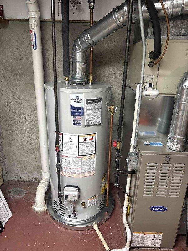 Successfully completed installation of a Bradford White 40-gallon natural gas water heater (model BG24056N, 40,000 BTU input) and Carrier furnace system in basement utility area. All gas connections, venting, and exhaust piping were installed to manufacturer specifications and code requirements. Connected copper supply lines with brass fittings to water heater, verified proper gas manifold pressure settings, and ensured adequate clearances for safe operation. Installed metallic vent piping with proper pitch and secured all ductwork connections to furnace unit. Verified all AHRI certification standards were met and operational instructions were clearly visible on equipment.
