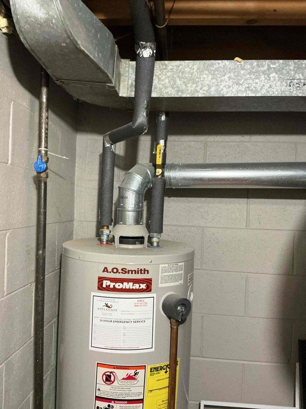 Completed estimate for tankless water heater installation to replace existing A.O. Smith ProMax conventional tank water heater in 1960s-era home. Assessed current utility room configuration including existing gas piping, venting system, electrical service, and water supply lines to determine requirements for tankless conversion. Documented existing installation with copper supply lines, black iron gas piping, and current venting arrangement through basement ceiling joists to facilitate accurate proposal for new tankless unit installation including necessary upgrades to gas line sizing, electrical service, venting modifications, and water supply connections.