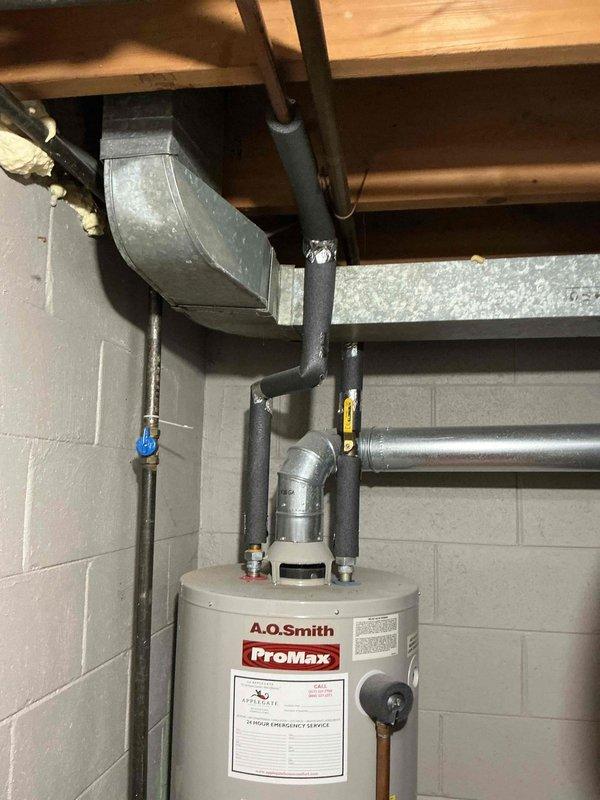 Completed estimate for tankless water heater installation to replace existing A.O. Smith ProMax conventional tank water heater in 1960s-era home. Assessed current utility room configuration including existing gas piping, venting system, electrical service, and water supply lines to determine requirements for tankless conversion. Documented existing installation with copper supply lines, black iron gas piping, and current venting arrangement through basement ceiling joists to facilitate accurate proposal for new tankless unit installation including necessary upgrades to gas line sizing, electrical service, venting modifications, and water supply connections.