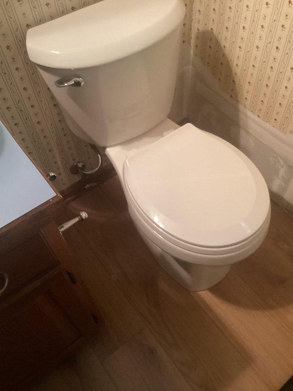 Reinstalled toilet in residential bathroom after replacing deteriorated wax ring seal. Removed existing toilet, inspected corroded flange assembly with rusted mounting hardware, installed new wax ring, and secured toilet back to floor with proper sealing. Verified water supply connections and tested for leaks to ensure proper operation.