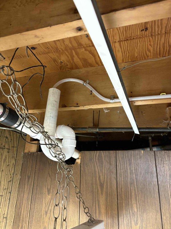 Responded to water leak call and completed plumbing reroute to address improper drainage issue. Kitchen sink drain line was redirected in basement area to prevent water from discharging directly onto washing machine. Installed new PVC drain waste piping with appropriate fittings and connections to properly route wastewater away from appliances. All connections secured and tested for proper drainage flow.