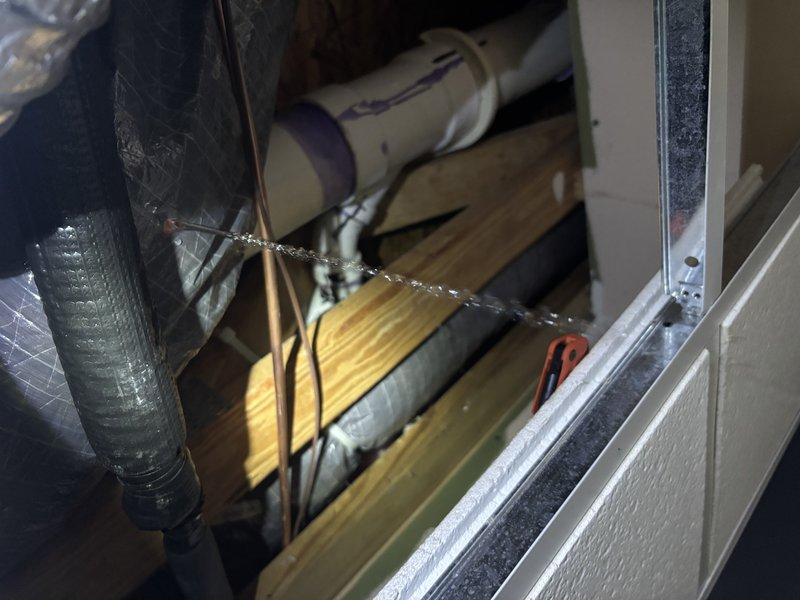 Responded to water leak complaint with condensation dripping into drop ceiling below air handler unit. Inspected evaporator coil assembly, drain pan, and condensate drain line for blockages or overflow conditions. Verified unit cooling operation normal with no refrigerant issues. Documented equipment condition and condensate management system with photos. Cleared condensate drain line obstruction and confirmed proper drainage to prevent further leakage into ceiling space.