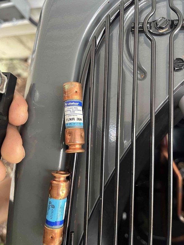 Responded to mechanical inspector's correction notice regarding oversized fuses on recently installed air conditioning condenser unit. Inspector identified 30-amp fuses installed in disconnect box, which exceeded the manufacturer's maximum overcurrent protection rating of 20 amps specified on the condenser nameplate. Documented existing installation with detailed photographs showing the oversized FLNR 30A Littelfuse fuses and condenser unit for inspector review and approval consideration per inspector's request.