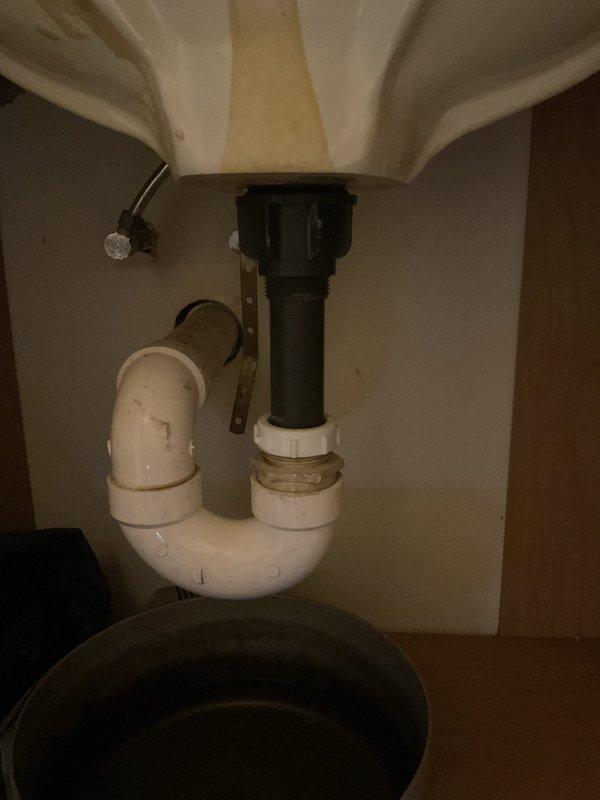 Responded to kitchen sink malfunction and conducted bathroom remodel assessment. Inspected kitchen sink plumbing assembly, including P-trap, tailpiece connections, and water supply lines showing mineral deposits and age-related discoloration. Evaluated bathroom space for remodeling scope, documenting existing toilet placement, wall dimensions, electrical outlet locations, and available clearances. Captured detailed measurements and photographic documentation of current plumbing configuration and bathroom layout to support future remodel planning.