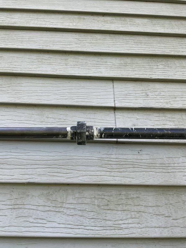 Installed new gas line from existing meter to interior of residence for fireplace application. Ran black iron pipe vertically from meter connection point up exterior wall, then horizontally along siding into house structure, terminating with stubbed connection ready for fireplace installation. Secured piping to exterior wall using appropriate mounting brackets and verified all connections for proper fitment and code compliance.