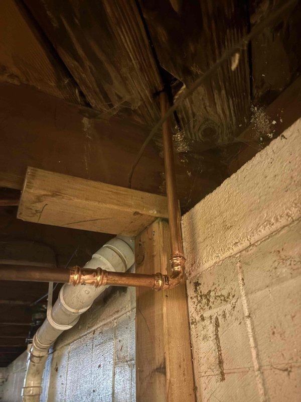 Completed comprehensive plumbing installation project including new water heater replacement, dual basket strainer installations, kitchen faucet replacement, and cable clearing of three separate drain lines servicing the bathtub, vanity, and bathroom sink, as well as kitchen sink drain. All copper supply lines were properly fitted with brass compression fittings and routed through floor joists in accordance with code requirements. PVC drainage systems were installed with proper venting and secured within the structural framing. Work was performed in confined crawl space and basement utility areas with all connections tested for proper operation and leak-free performance.