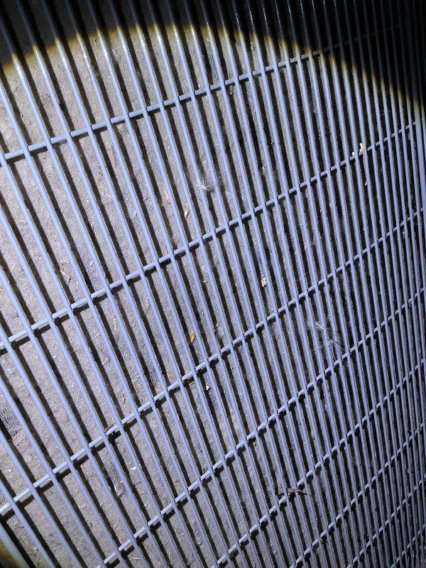 Completed annual cooling maintenance on two systems: a 2-year-old EnergiAir unit (model WT 03-2034) and a 12-year-old EcoAir unit. Performed comprehensive inspection and tune-up procedures on both systems. Documented condenser coil conditions with photographs showing moderate dust and debris accumulation on fin surfaces and protective grille assemblies. All standard preventive maintenance tasks completed per manufacturer specifications.