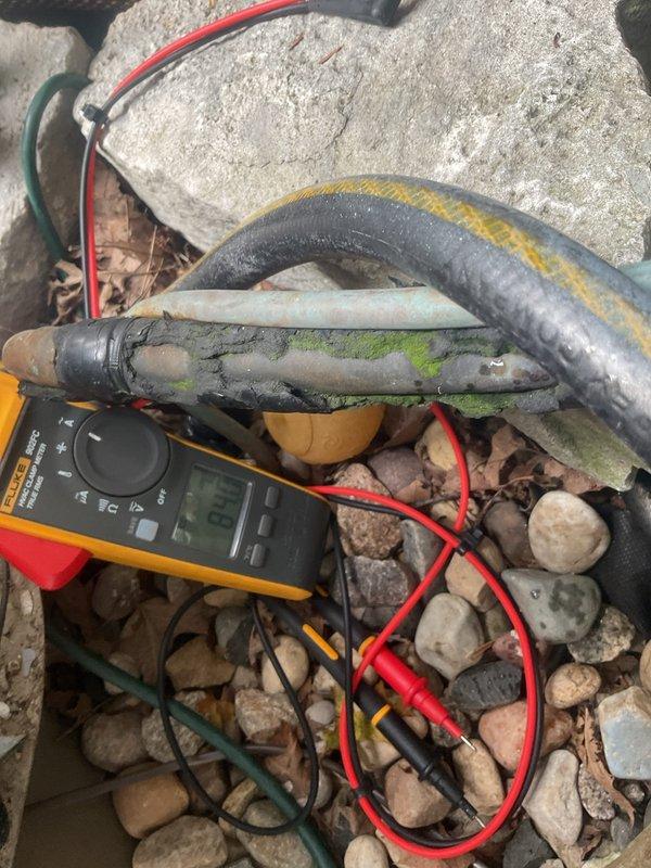 Responded to no cooling call with outdoor unit not operating. Upon arrival, found outdoor condenser unit with significant debris accumulation in base pan and electrical system issues. Used multimeter to diagnose electrical circuit and confirmed loss of power to outdoor unit. Identified deteriorated wiring connections and corroded components at outdoor unit. Cleared debris from condenser base pan including leaves, organic matter, and deteriorated insulation material. Inspected condenser coil which appeared clean. Tested electrical connections and verified proper voltage readings. Addressed thermostat communication issues previously reported by customer. Restored power to outdoor unit and verified proper operation of system.