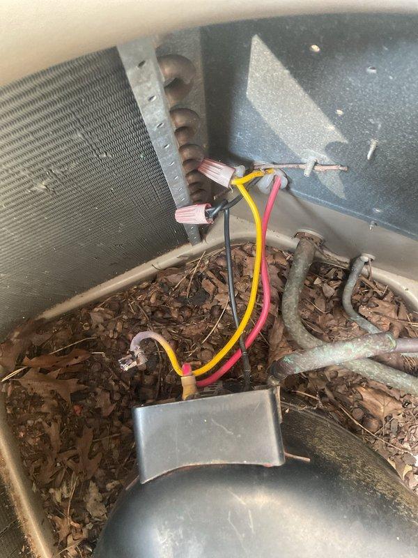 Responded to no cooling call with outdoor unit not operating. Upon arrival, found outdoor condenser unit with significant debris accumulation in base pan and electrical system issues. Used multimeter to diagnose electrical circuit and confirmed loss of power to outdoor unit. Identified deteriorated wiring connections and corroded components at outdoor unit. Cleared debris from condenser base pan including leaves, organic matter, and deteriorated insulation material. Inspected condenser coil which appeared clean. Tested electrical connections and verified proper voltage readings. Addressed thermostat communication issues previously reported by customer. Restored power to outdoor unit and verified proper operation of system.