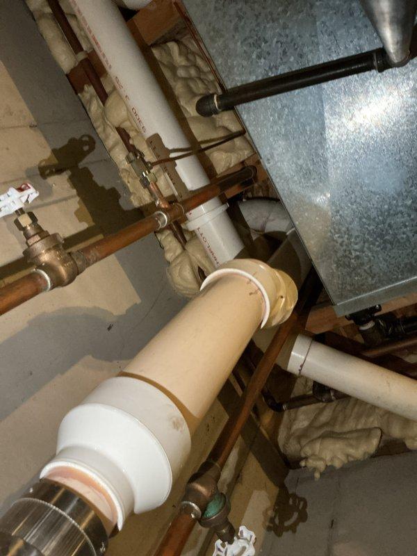 Responded to service call for water heater leak and potential furnace area water leak. Upon inspection, identified active leak from water heater connections in utility room. Examined all plumbing connections, copper supply lines, shut-off valves, and PVC drainage system. Assessed water heater condition and surrounding mechanical systems including water softener installation. Inspected furnace area for reported moisture concerns and traced potential leak sources. Documented equipment conditions and leak locations with photographs for service records. Water heater appears to be approximately 5 years old based on initial service request information.