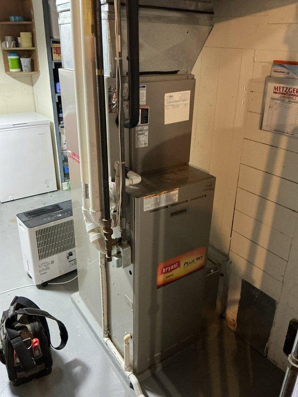Completed annual cooling maintenance on 21-year-old Bryant system with 2022 condenser motor replacement. Performed comprehensive tune-up including refrigerant level verification, electrical connection inspection, condensate drain clearing, and air handler filter service on stacked HVAC unit located in basement mechanical room. All components operating within manufacturer specifications; customer notified of later arrival time via voicemail.