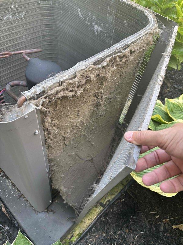 # NC-No Cool Service Completed

Responded to no cooling complaint with evaporator coil icing and insufficient cooling. Upon arrival, found outdoor condenser coils heavily restricted with dirt, dust, and debris accumulation, severely limiting airflow and heat transfer capability. Removed side panels to access coil surfaces and documented extensive buildup on aluminum fins.

Performed thorough coil cleaning of outdoor condenser unit, removing thick layers of accumulated dirt and organic matter from fin surfaces. Cleaned all accessible coil faces to restore proper airflow through heat exchanger. Addressed customer concern regarding previous service visit by ensuring complete and proper cleaning of all components.

Verified system operation after cleaning. Unit cooling properly with no further coil icing observed. Recommended regular maintenance to prevent future coil restriction issues on this 12-year-old system.