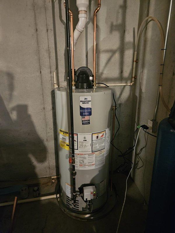 Installed new Bradford White 50-gallon automatic storage water heater in basement utility room. Connected all water supply lines using copper piping, installed PVC venting system, and completed electrical connections per manufacturer specifications. Unit tested and verified operational with all safety labels and energy guide documentation properly displayed.