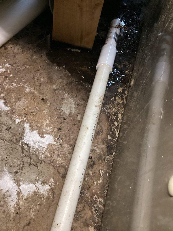 Completed annual cooling maintenance on 31-year-old Amana air conditioning system. Performed comprehensive tune-up including system inspection, cleaning, and operational testing. Documented crawlspace conditions showing PVC condensate drain line with accumulated dirt and debris on concrete floor surface, along with evidence of moisture accumulation in utility area beneath unit.