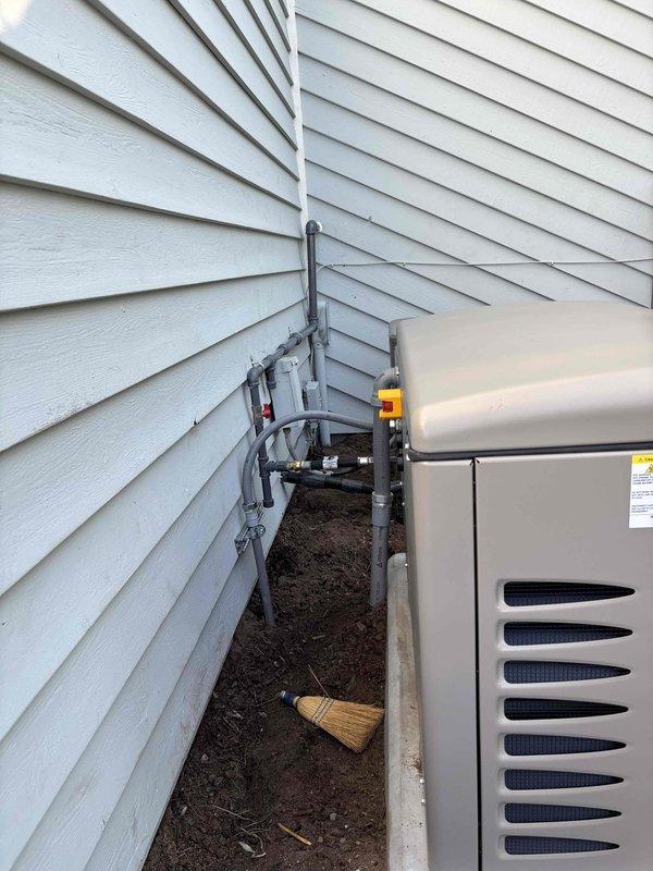 Successfully installed 26KW Kohler standby generator with 200A service upgrade at residential property. Coordinated utility disconnect and reconnect services, obtained electrical permit, and completed all required inspections including gas pressure testing. Generator unit was positioned on concrete pad in side yard utility area with proper clearances, connected gray PVC conduit and refrigerant lines secured with mounting brackets along exterior siding, and integrated with existing electrical system. All work performed to code specifications and passed final inspection.