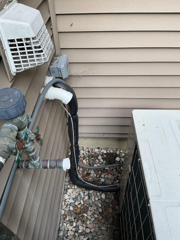 Completed annual cooling maintenance on 2021 Amana heat pump system. Performed comprehensive tune-up including inspection of outdoor condensing unit, refrigerant lines, and associated components. Verified proper operation of all electrical connections, drainage system with PVC condensate lines, and copper refrigerant piping showing normal weathering patina. Unit operating within manufacturer specifications with adequate airflow through condenser coil and proper clearance around equipment on concrete pad.
