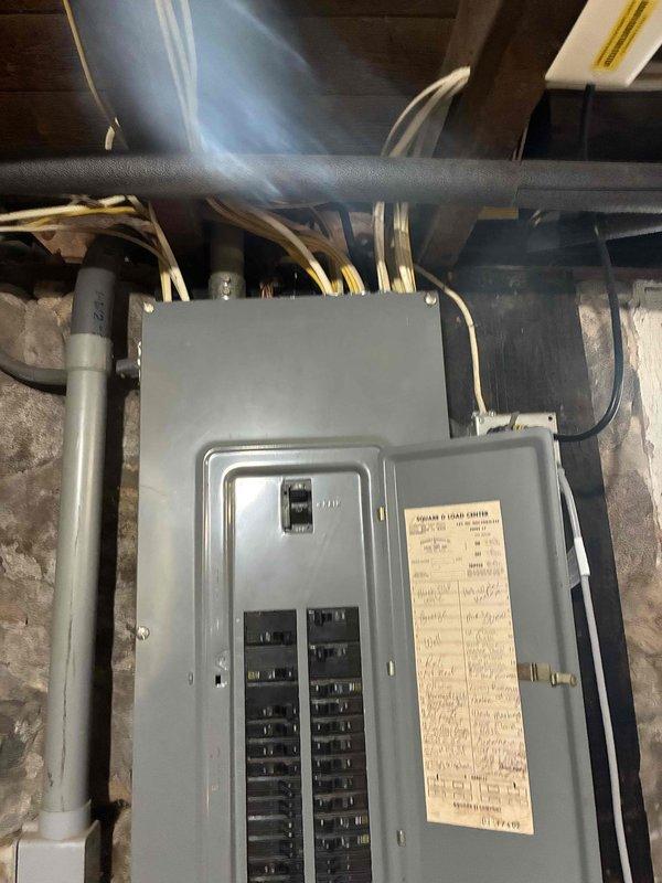Completed estimate for central air conditioning installation in home currently equipped with boiler heating system. Property has existing ductwork previously installed, which was documented and assessed for compatibility with proposed AC system. Also evaluated feasibility of adding forced air gas furnace to work in conjunction with or replace existing boiler system. Photographed electrical panel installation in basement utility area to assess current electrical capacity and determine requirements for AC equipment, including inspection of breaker panel configuration, available circuits, and conduit routing for potential HVAC electrical connections.