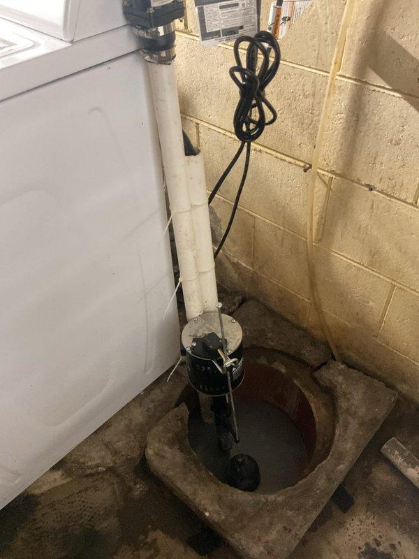 Responded to drainage complaint where washing machine discharge was backing up into kitchen sink. Upon inspection, accessed basement plumbing system and identified improper drain line configuration in the washing machine standpipe connection. The issue was caused by inadequate venting and potential partial blockage in the shared drain line between the laundry and kitchen fixtures.

Examined the PVC drainage system running through the basement ceiling joists and confirmed the washing machine drain was improperly tied into the kitchen sink drain line without proper venting, creating a siphoning effect during wash cycles. Verified sump pump operation and checked all visible drain connections for proper pitch and secure fittings. Cleared the affected drain line and confirmed proper water flow from both the washing machine and kitchen sink. System now draining properly with no backup issues observed during testing.