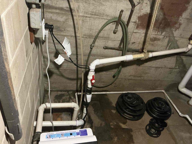 Replaced failed sump pump unit and upgraded laundry drainage system by removing inadequate 1" electrical conduit previously used for drain line and installing proper 2" PVC piping with appropriate fittings and slope for code-compliant drainage. New sump pump installed and tested for proper operation, with all plumbing connections secured and system verified functional.