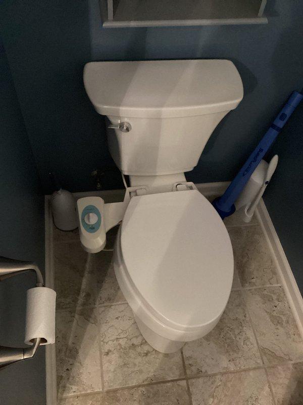Responded to emergency service call for non-operational sump pump with reported sewage odor and slow-draining lower level toilet. Upon inspection, found sump pump basin with PVC discharge piping and confirmed pump failure. Assessed mechanical room conditions and identified moisture accumulation around pit area indicating drainage issues. Inspected affected bathroom fixture and verified sluggish flush performance consistent with potential drainage obstruction or pump system malfunction. Documented equipment conditions including basin configuration, discharge piping with blue valve assembly, and surrounding utility area. Evaluated correlation between non-functioning sump pump and compromised toilet drainage, determining pump failure was impacting overall lower level plumbing system performance.