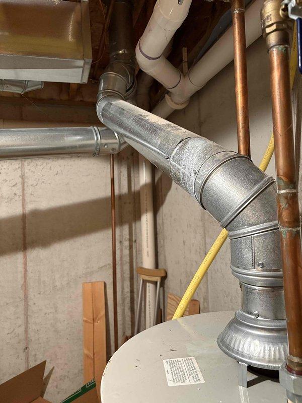 Responded to service call for 11-year-old Bradford White water heater with extinguished pilot light. Upon arrival, inspected unit and surrounding utility area, documented existing conditions including ductwork, plumbing connections, and water heater installation. Successfully diagnosed pilot light issue, relit pilot assembly, and verified proper ignition and burner operation to restore hot water service.