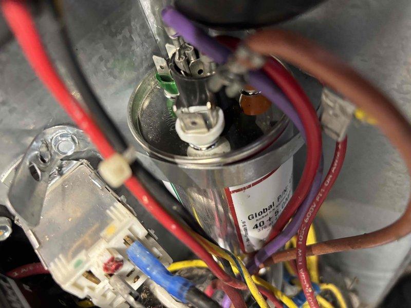 Responded to no-cool service call on 13-year-old residential air conditioning system where outdoor unit fan was not operating following recent tune-up. Diagnosed failed run capacitor preventing condenser fan motor from starting. Replaced defective 40 MFD dual capacitor with new unit, verified proper wire connections to compressor and fan motor terminals, and restored system to normal operation with condenser fan running correctly.