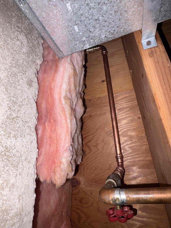 Assessed outdoor spigot installation in crawl space area with exposed copper piping and U-bend configuration. Documented existing plumbing setup including shutoff valve, pipe routing through wooden framing, and surrounding fiberglass insulation conditions. Provided quote for complete outdoor spigot replacement based on accessibility and current system configuration.