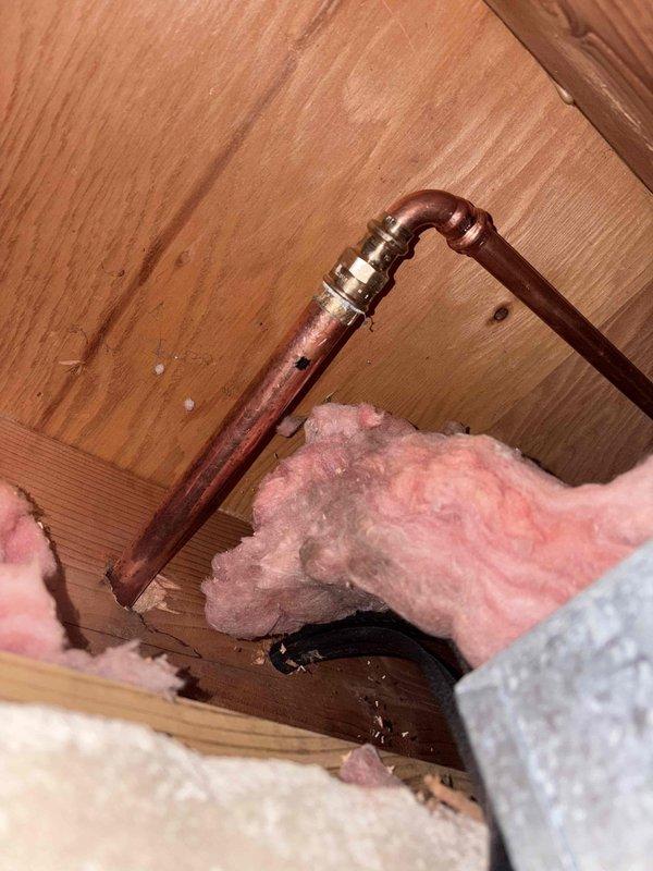 Assessed outdoor spigot installation in crawl space area with exposed copper piping and U-bend configuration. Documented existing plumbing setup including shutoff valve, pipe routing through wooden framing, and surrounding fiberglass insulation conditions. Provided quote for complete outdoor spigot replacement based on accessibility and current system configuration.