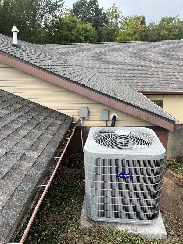 Completed full HVAC system installation including Carrier brand furnace, air conditioning condenser unit, and water heater. Installed furnace in basement/utility room with proper plenum connections, air filtration system, condensate drain lines via white PVC piping, electrical conduit, and flexible ductwork connections. Mounted outdoor AC condenser unit on concrete pad with appropriate electrical disconnect box and conduit routing to exterior wall. All equipment properly vented, connected to ductwork distribution system, and tested for operation. System installation meets manufacturer specifications and local code requirements.