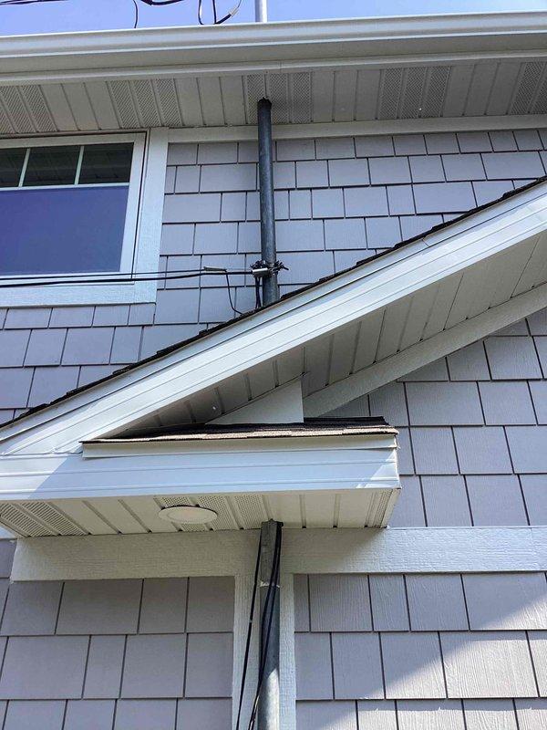 Conducted on-site assessment for generator installation at single-family residence with no existing backup power system. Evaluated existing electrical service infrastructure, including main meter assembly with Milbank equipment and service panel mounted on exterior gray shake siding. Documented current electrical configuration with multiple conduit runs along building exterior and assessed available space for generator placement and associated transfer switch installation. Photographed electrical service entrance, meter base, disconnect boxes, and building exterior to determine optimal equipment location and electrical tie-in requirements for proposed automatic standby generator system.