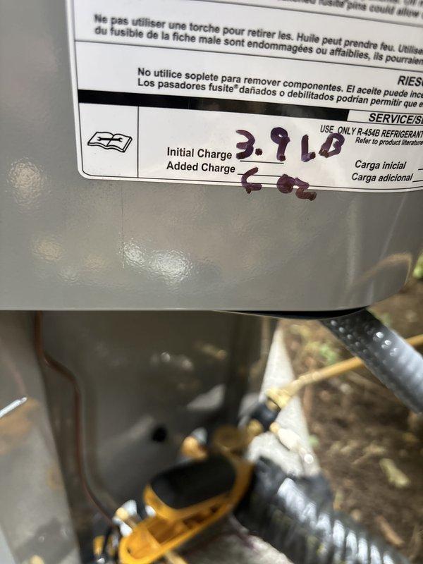 Completed full installation of new furnace and air conditioning system at residential property. Outdoor condenser unit was positioned on concrete pad beneath elevated deck structure with proper electrical disconnect box installed and all refrigerant lines connected. System was charged with refrigerant per manufacturer specifications, with initial charge of 39 pounds and additional 6 ounces added to achieve optimal operating levels. All electrical connections, copper line sets, and condensate drainage were installed to code, and unit was tested for proper operation and cooling performance.