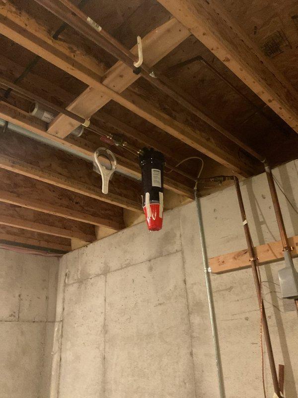 Responded to plumbing leak in basement utility/furnace room that had been ongoing for two weeks. Upon arrival, found significant water accumulation on concrete floor with standing water and multiple puddles throughout the space. Located source of leak in copper piping system suspended from floor joists. Removed and replaced failed section of copper pipe, including associated fittings and mounting brackets. Tested system under pressure to verify repair integrity and confirm no additional leaks present. Cleaned up standing water and verified proper drainage. System restored to full operational status with no further water intrusion detected.