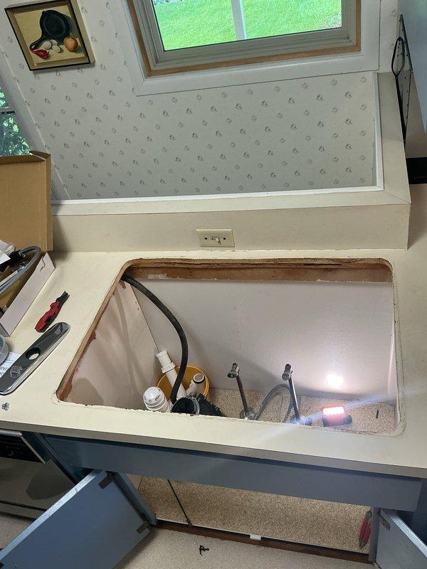 Completed return visit to RV for quoted kitchen faucet replacement. Removed existing corroded faucet assembly and addressed water staining around sink mounting area. Installed new faucet with proper mounting hardware and reconnected water supply lines to both hot and cold connections. Verified all plumbing connections beneath sink were secure and tested system for proper operation and leak-free performance.
