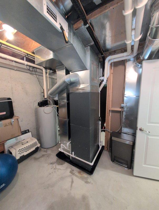 Completed full air conditioning system replacement including outdoor condenser unit and indoor air handler. New condenser was installed on existing concrete pad with proper clearances maintained from landscaping and structure. Indoor air handler was positioned in basement mechanical room with all ductwork connections properly sealed and secured to existing distribution system.