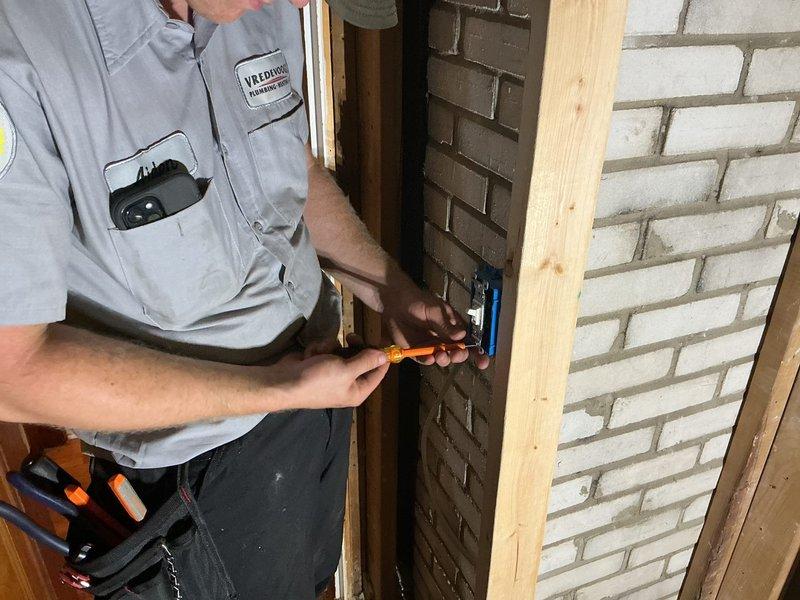 Completed electrical wiring installation for bathroom exhaust fan in residential property. Accessed wall cavity through existing openings, ran new electrical circuit through wall studs, and installed junction box on brick wall surface. Connected wiring to outlet box using proper electrical connections and secured all components according to code requirements.
