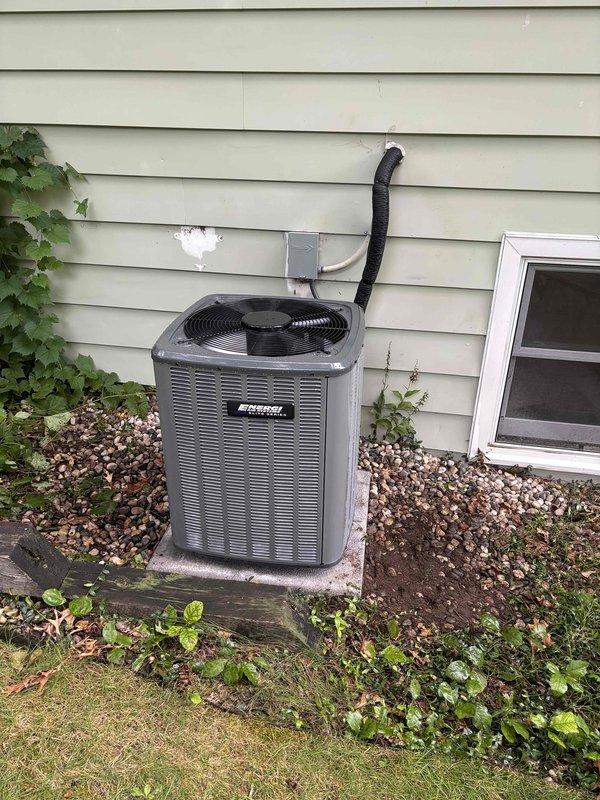 Completed full HVAC system installation including new high-efficiency furnace with PVC intake and exhaust venting in basement utility area, mounted on protective base pad with proper clearances. Installed ductwork connections with reflective insulation and flexible ducting, completed electrical conduit work and wiring. Added outdoor mini-split condenser unit on concrete pad against exterior wall with black line set run through wall penetration, secured with mounting bracket. Verified all components operational, system tested and commissioned successfully.