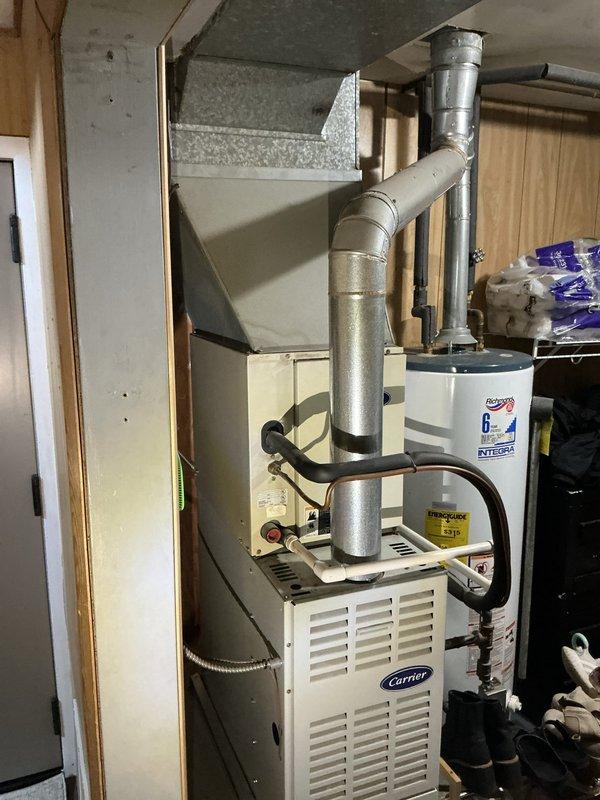 Conducted comprehensive HVAC assessment for new homeowner at 3PM. Evaluated existing Carrier furnace system with associated ductwork and examined electrical panel configuration in unfinished basement area. Documented current equipment conditions, circuit breaker panel setup with main disconnect, and mechanical room layout including furnace, water heater, and distribution systems. Photographed all major components to provide detailed estimate for air conditioning system installation and integration with existing heating infrastructure.