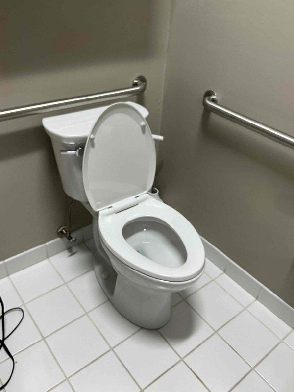 Responded to plumbing leak concern and successfully replaced broken toilet handle and associated hardware. Accessed facility using provided entry code at rear entrance near patio furniture. Completed repair work on accessible bathroom toilet, restoring full functionality to flush mechanism. Documented completed installation with photos showing properly functioning fixture with grab bars and clean tile flooring.