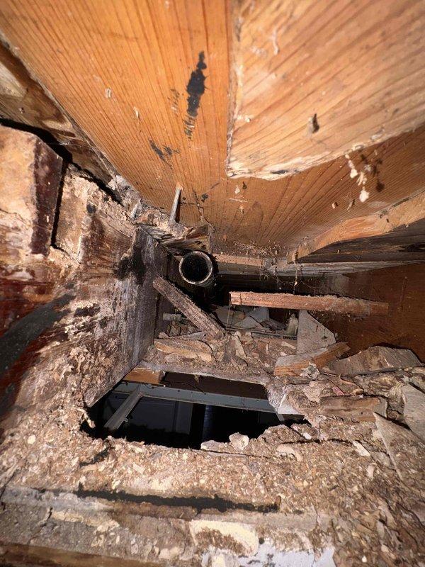 Completed repair of bathtub overflow assembly and trap system. Accessed and replaced deteriorated plumbing components showing extensive water damage and structural wear in the drain assembly area. All connections tested and verified leak-free upon completion.